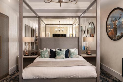 艾尔Brig o' Doon House Hotel的卧室配有带枕头的天蓬床