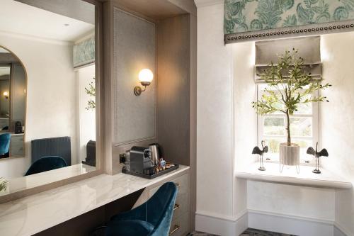 艾尔Brig o' Doon House Hotel的酒店客房带镜子和蓝椅