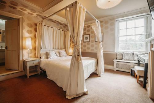 惠灵顿Old Orleton Inn的一间卧室设有天蓬床和窗户。