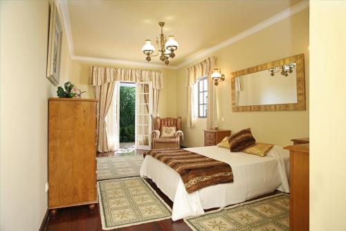 阿尔布费拉Villa Jumar的一间卧室配有一张床、镜子和椅子