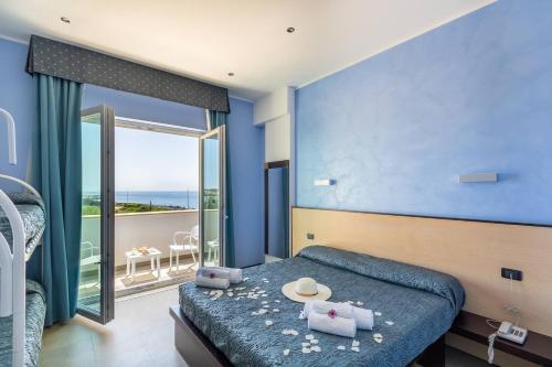 托雷圣乔万尼乌乔尼科酒店的一间蓝色卧室,配有一张床和一个阳台