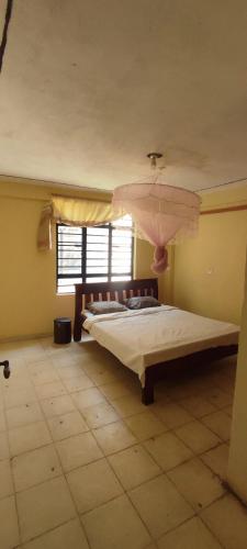 2 bedrooms furnished houses in Mwea的一间卧室配有一张带粉红色伞的大床