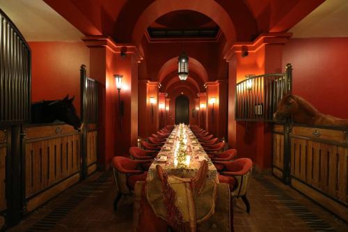 马拉喀什塞尔曼马拉喀什酒店的长长的用餐室配有长桌子和椅子