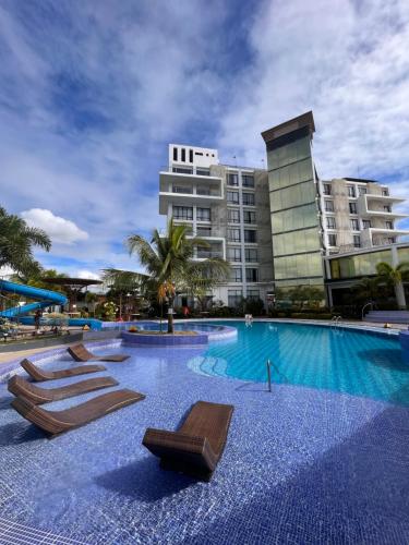 Lapu Lapu CityWinrich Hotel的一座大楼前的游泳池,配有躺椅