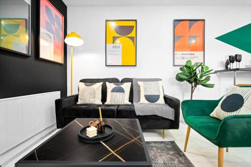 伯明翰Luxury 3 Bedroom Apartment - Terrace - WiFi - Smart TV 1MR的客厅配有黑色沙发和绿色椅子