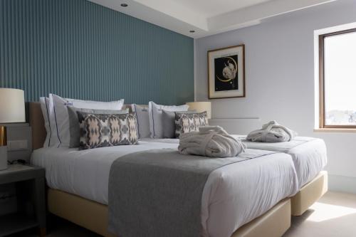 里斯本VIP Executive Suites do Marquês Hotel的卧室设有两张床铺和绿色的墙壁