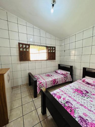 大坎皮纳Casa Mandacaru Espaço completo的客房设有两张床和窗户。