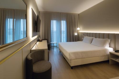 米兰Hotel Nasco的配有一张床和一把椅子的酒店客房