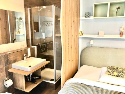 鲁斯特R＆J酒店的一间带水槽和淋浴的浴室以及一张床