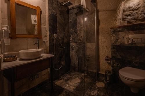格雷梅阿伊迪尼尔岩洞酒店的带淋浴和盥洗盆的脏浴室