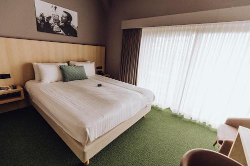 杜柏Hôtel Five Nations的一间卧室设有一张大床和大窗户