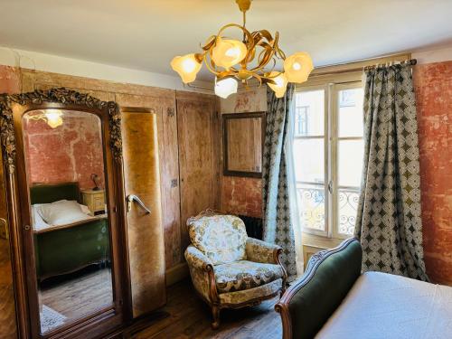 勒布伊Epicerie Vieille du Puy en Velay的一间卧室配有镜子、椅子和镜子