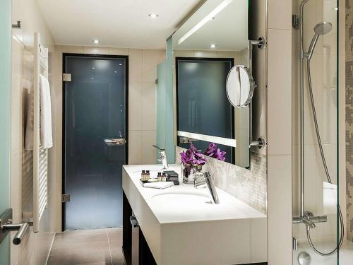 慕尼黑慕尼黑铂尔曼酒店的一间带水槽和淋浴的浴室