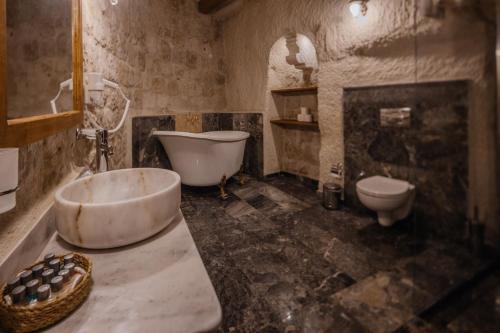 格雷梅阿伊迪尼尔岩洞酒店的带浴缸、卫生间和盥洗盆的浴室