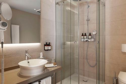 柏林NH酒店柏灵选帝侯大街店的一间带水槽和玻璃淋浴的浴室