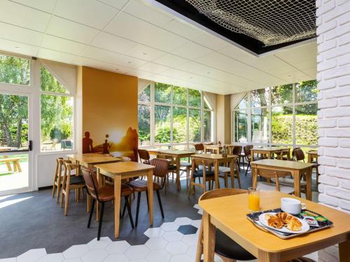 博比尼Ibis Styles Bobigny Centre Préfecture的餐厅设有桌椅和窗户。