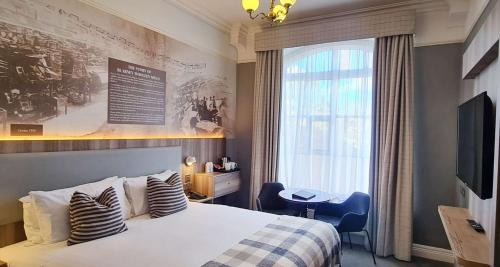 布拉尼Blarney Woollen Mills Hotel - BW Signature Collection的酒店客房设有床和窗户。