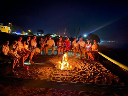 马查利亚La Fogata的一群人坐在海滩上的火堆旁