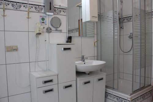 韦尼格罗德REGIOHOTEL Aparthotel Wernigerode的白色的浴室设有水槽和淋浴。