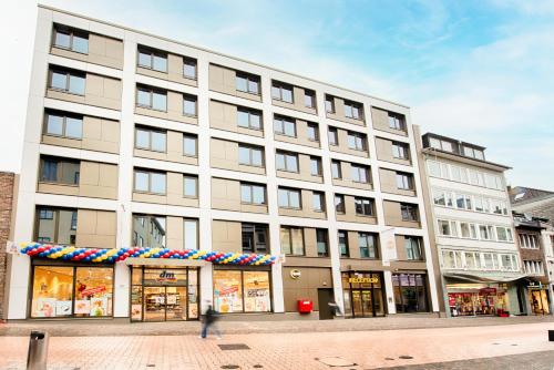 亚琛B&B Hotel Aachen-City的一条城市街道上的白色大建筑