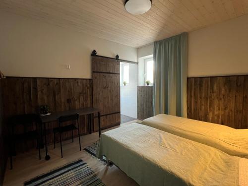 LemsiKihnu Sadama Öömaja的一间卧室配有一张床、一张桌子和一张桌子