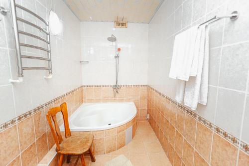 撒马尔罕Yangi Sharq的带浴缸和椅子的浴室