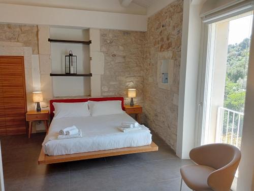 拉古萨Itria Palace的一间卧室配有一张带两把椅子的床和一扇窗户