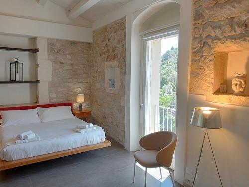 拉古萨Itria Palace的卧室配有床、椅子和窗户。