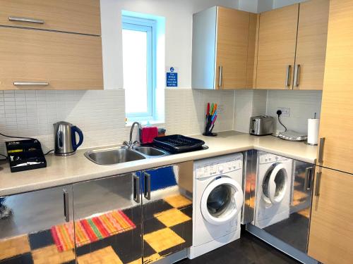 达格纳姆Forsyth Court Apartment - Two bedroom的厨房配有2台洗衣机和水槽