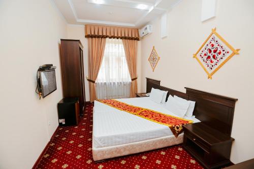 撒马尔罕Yangi Sharq的一间卧室设有一张大床和一个窗户。