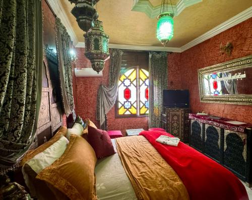梅克内斯Riad Mogador的一间卧室设有一张红色墙壁和窗户的床