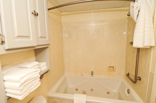 默特尔比奇沙南假日酒店的带浴缸和部分毛巾的浴室。