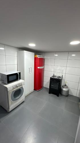 约恩维利Alves residencial的厨房配有洗衣机和红色冰箱。