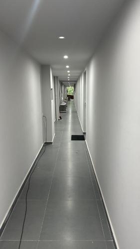 约恩维利Alves residencial的长长的走廊,设有白色的墙壁和瓷砖地板