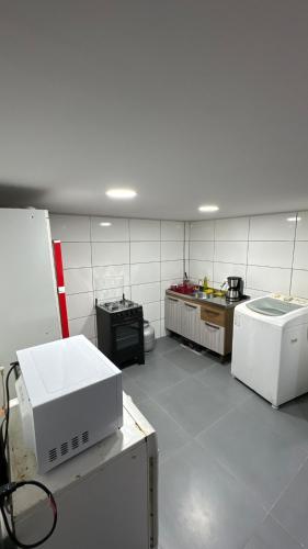 约恩维利Alves residencial的一间设有白色瓷砖墙的大厨房