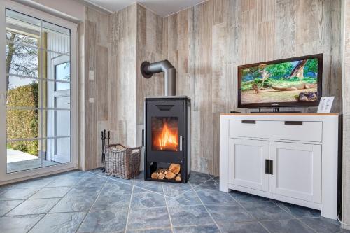 特拉森海德Ferienhaus zur frischen Brise - Whg. 1的客厅设有壁炉和电视。