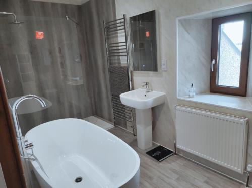 SandayCastlehill, Sanday的浴室配有盥洗盆、卫生间、浴缸和盥洗盆。
