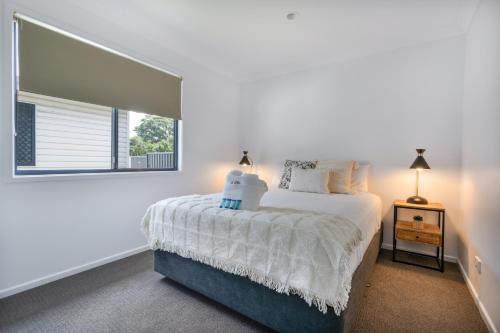 赫维湾Tasman Holiday Parks - Fraser Coast的白色的卧室设有床和窗户