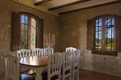 瓦德诺比斯Masia Villa Pilar Valderrobres的一间带木桌和白色椅子的用餐室