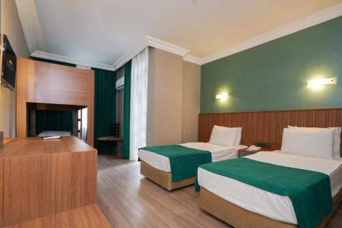阿拉尼亚ERGÜN OTEL的酒店客房设有两张床和电视。
