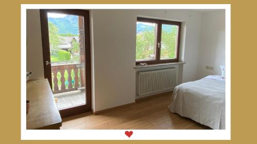 Flintsbach am InnBerghupferl-Alm - do legst di nieda的一间卧室设有一张床和一个开放式窗户。