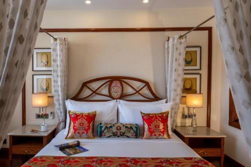 列城格兰德龙拉达克酒店的一间卧室配有一张带两张桌子和两盏灯的床。