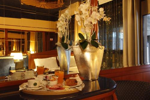 莱尼亚诺Hotel City Legnano的一张桌子,上面有一盘食物和花瓶