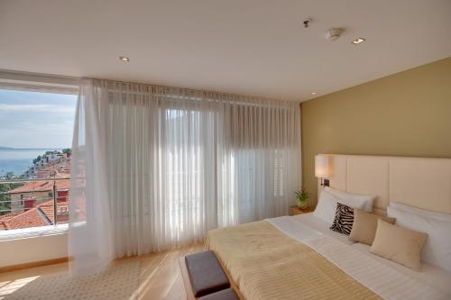 奥帕提亚ASTORIA Hotel Opatija的一间卧室设有一张大床和一个大窗户
