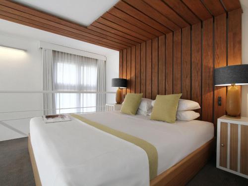 布宜诺斯艾利斯HTL9七月寓所酒店的卧室设有一张白色大床和一扇窗户。