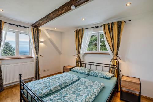 LaufFerienhaus S' Äckerle的一间卧室设有一张床和两个窗户。