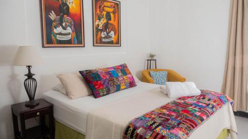 弗洛勒斯AMINA Inn的一间卧室配有一张带彩色毯子的床