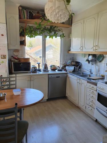 胡丁厄Unique homestay的厨房配有白色橱柜和木桌