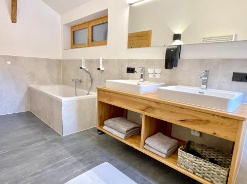 塞尔赖因山谷格里斯Appartements Zur Post的浴室配有2个盥洗盆和1个浴缸。