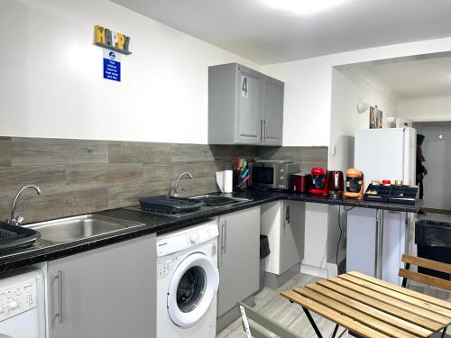 Havering atte BowerPenn Gardens Flat 1 - 2 - 3 & 4 Apartments的厨房配有水槽和洗衣机